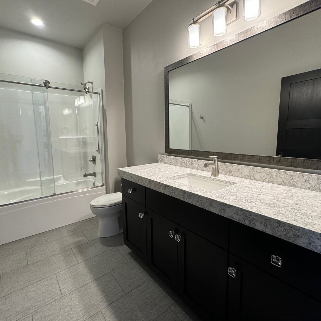 A bathroom with a toilet , sink , and mirror.