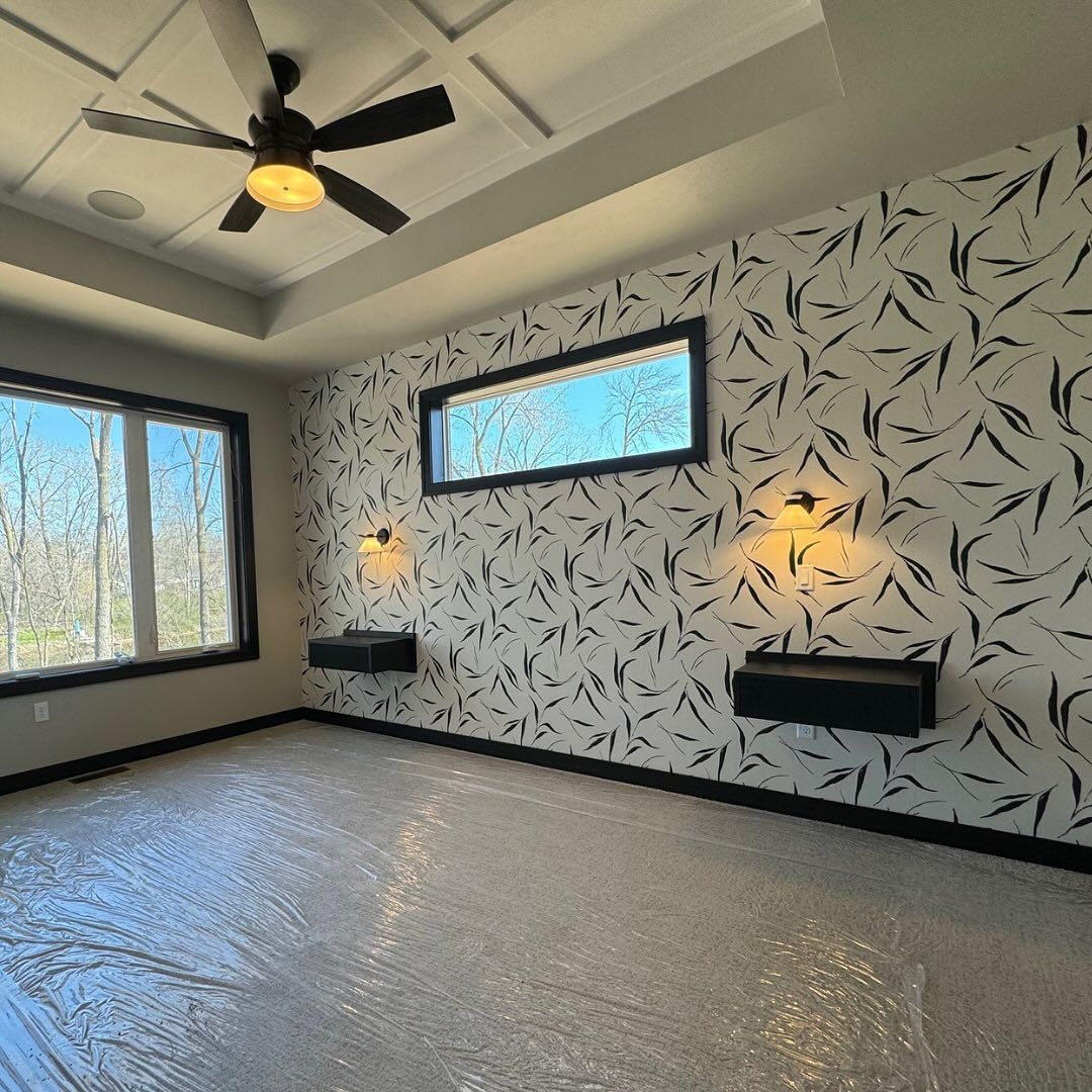 An empty room with a ceiling fan and a window.