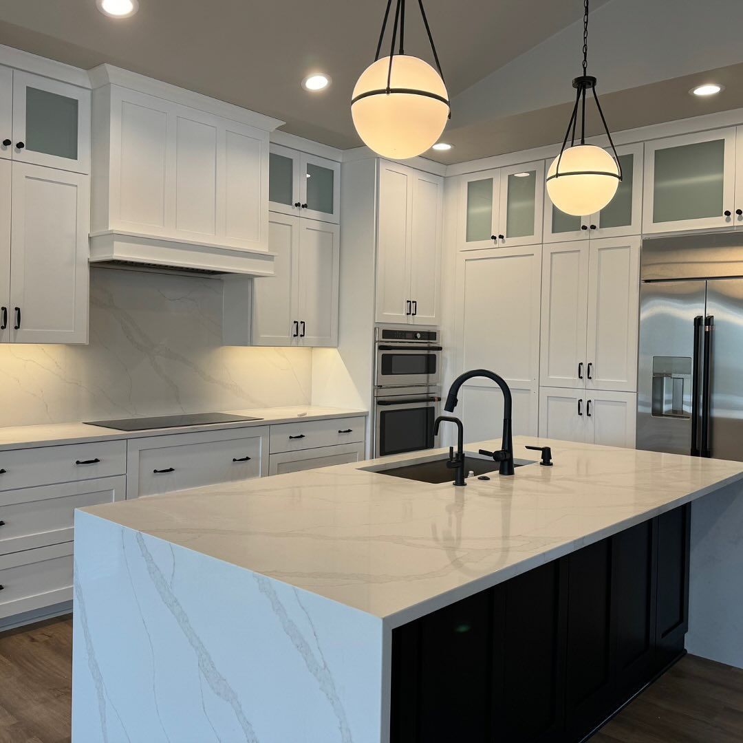 A kitchen with white cabinets and a large island