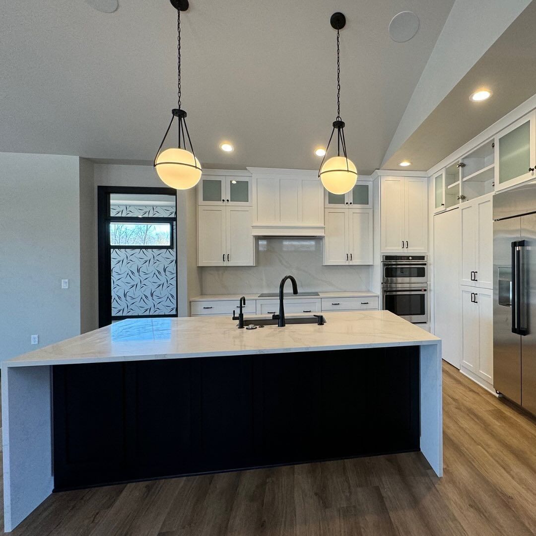 A kitchen with a large island and white cabinets