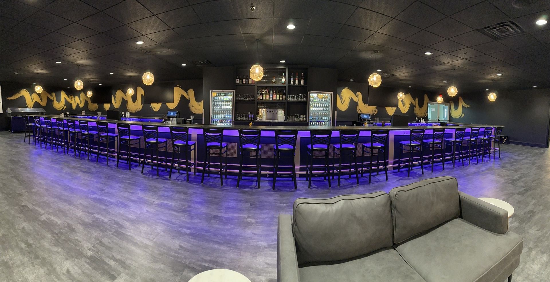 A large room with a couch and a bar.