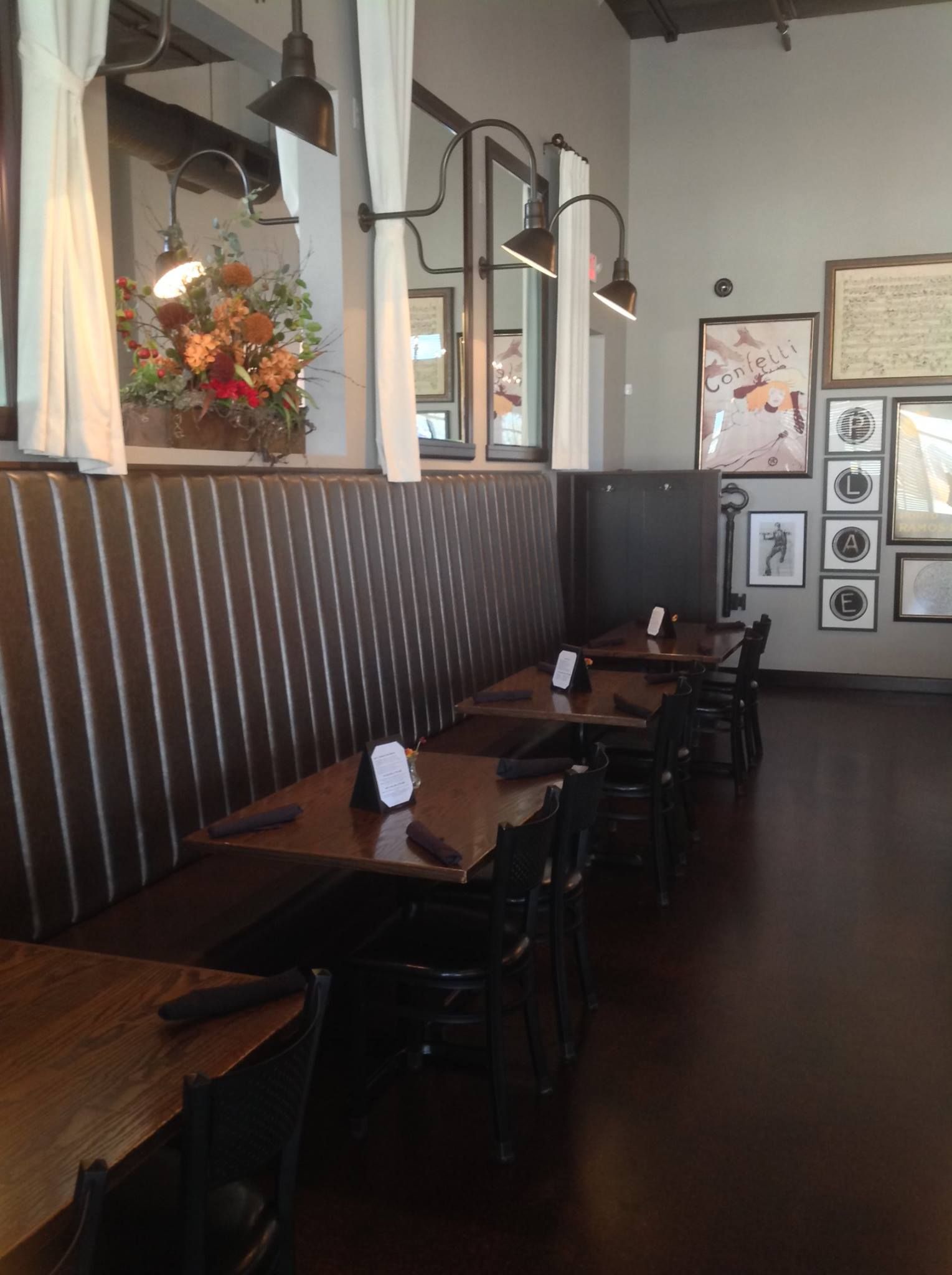 A restaurant with tables and chairs and pictures on the wall