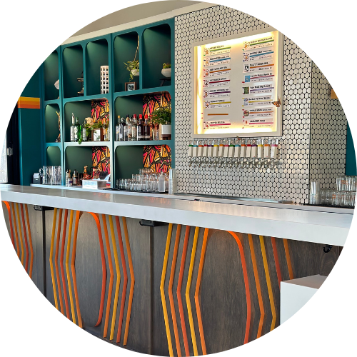 A kitchen with white cabinets and wooden floors in a circle.