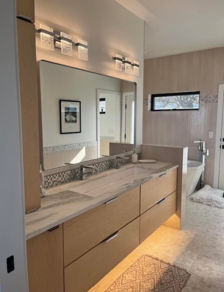 A bathroom with two sinks and a large mirror