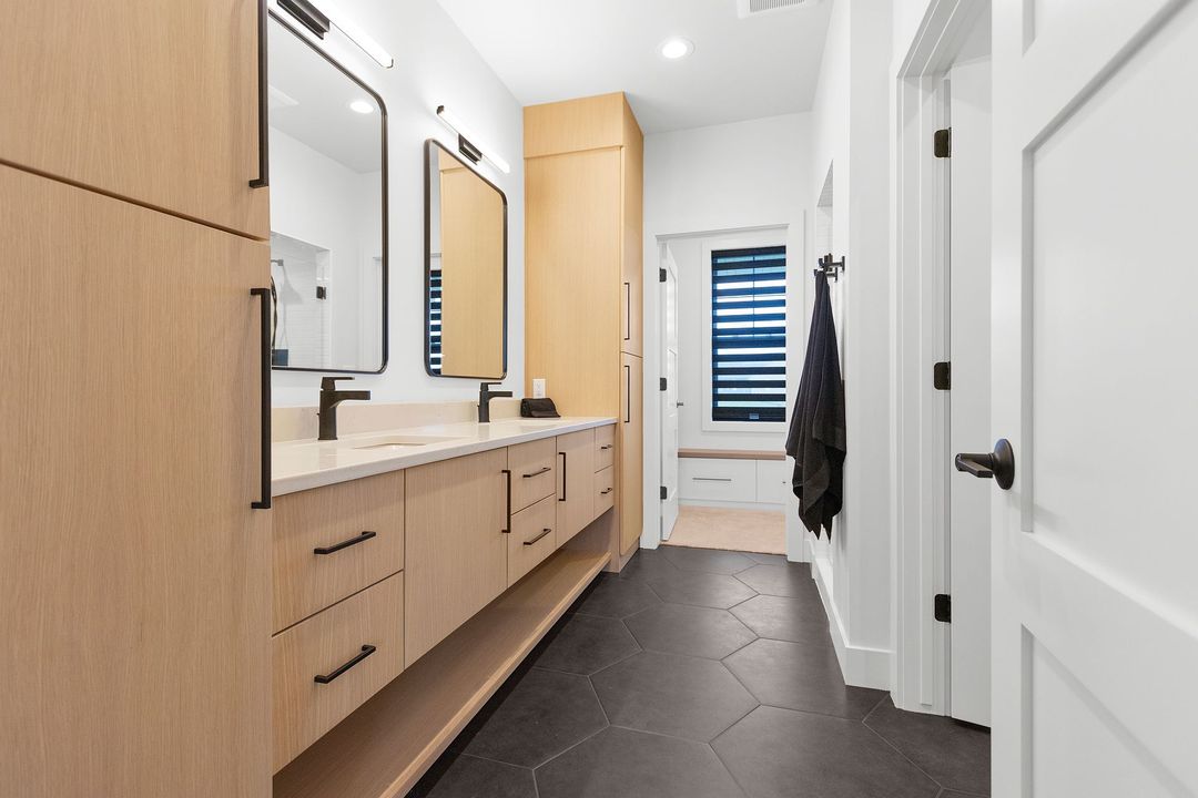 A bathroom with two sinks and two mirrors.