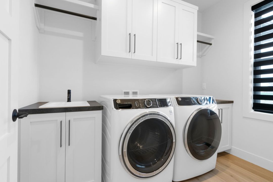 A laundry room with a washer and dryer and a sink.