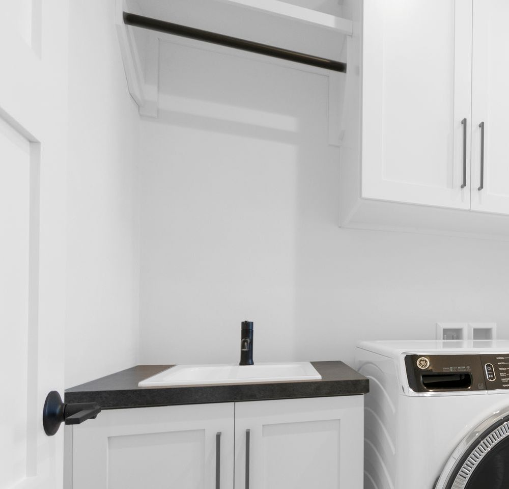 A laundry room with a washer and dryer and a sink