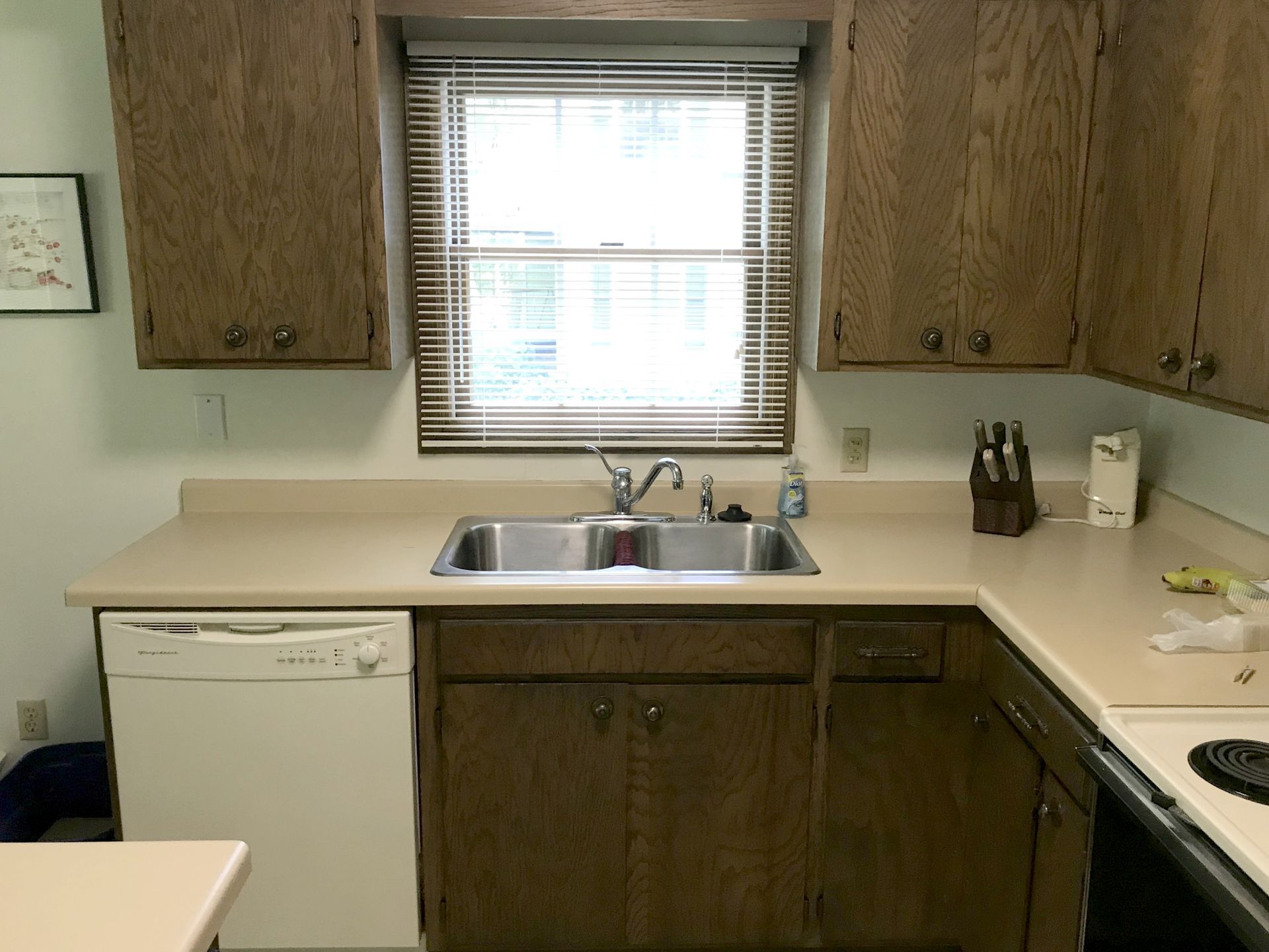 A kitchen with a sink a dishwasher and a window