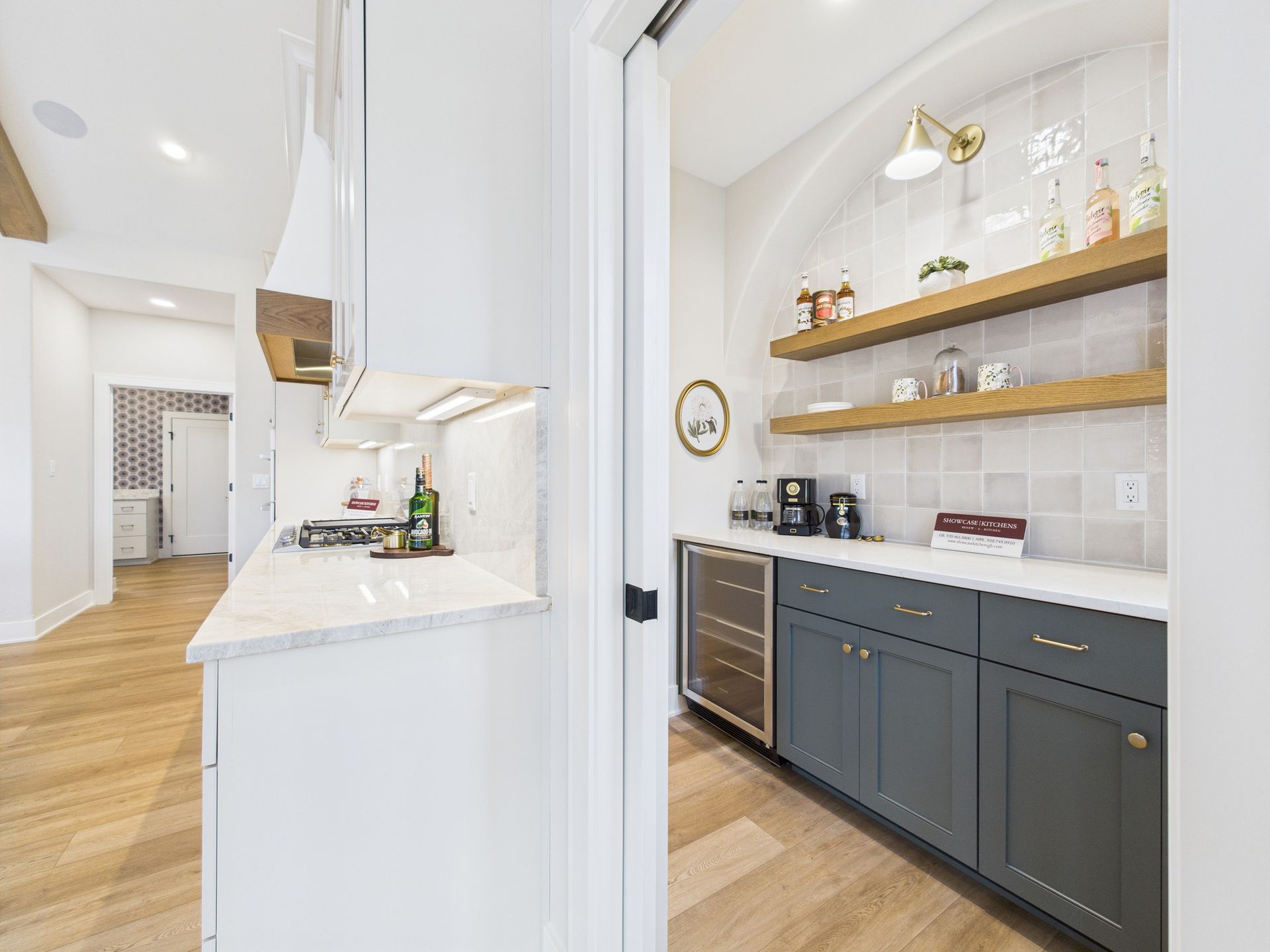 Kitchen with pantry: gray cabinets, wine fridge, wooden shelves, white countertops, and light wood floors.