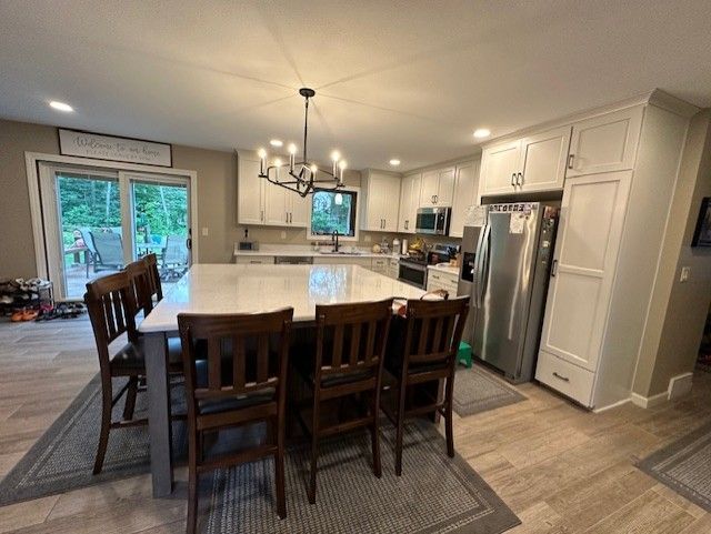 There is a large island in the middle of the kitchen with a table and chairs.