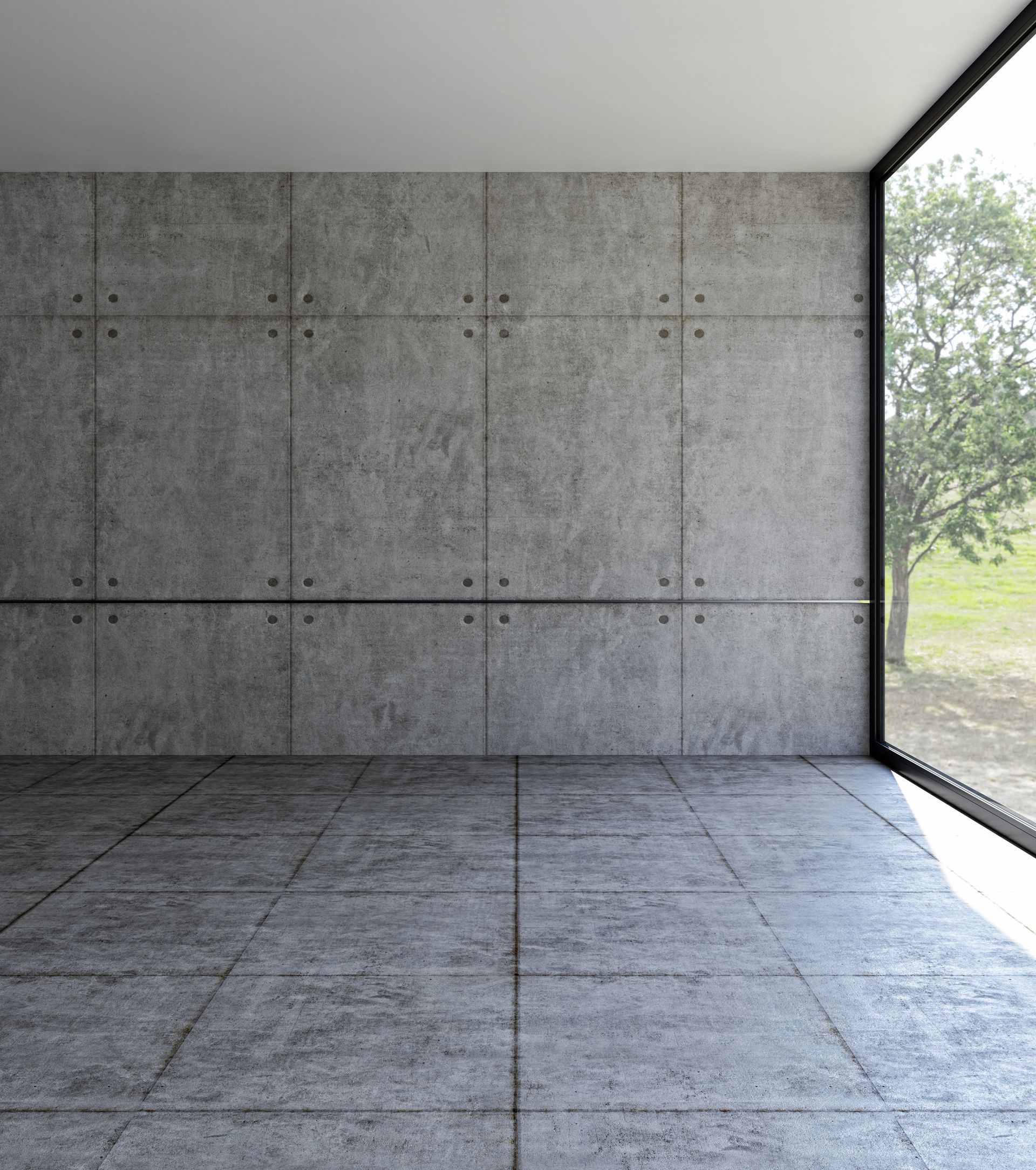 An empty room with concrete walls and a large window.