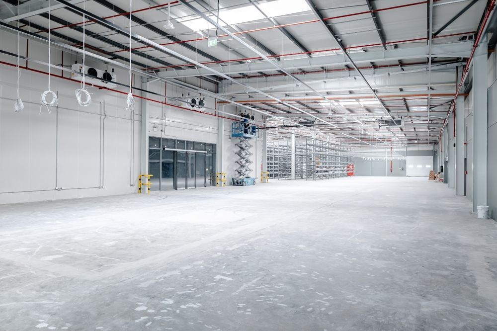 A large empty warehouse with a concrete floor and ceiling.