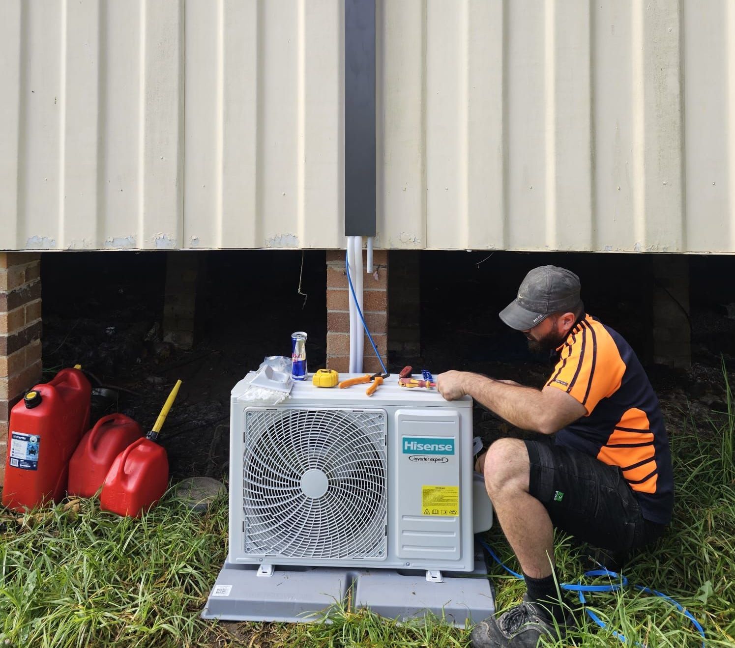 A man is using a drill to fix an air conditioner.