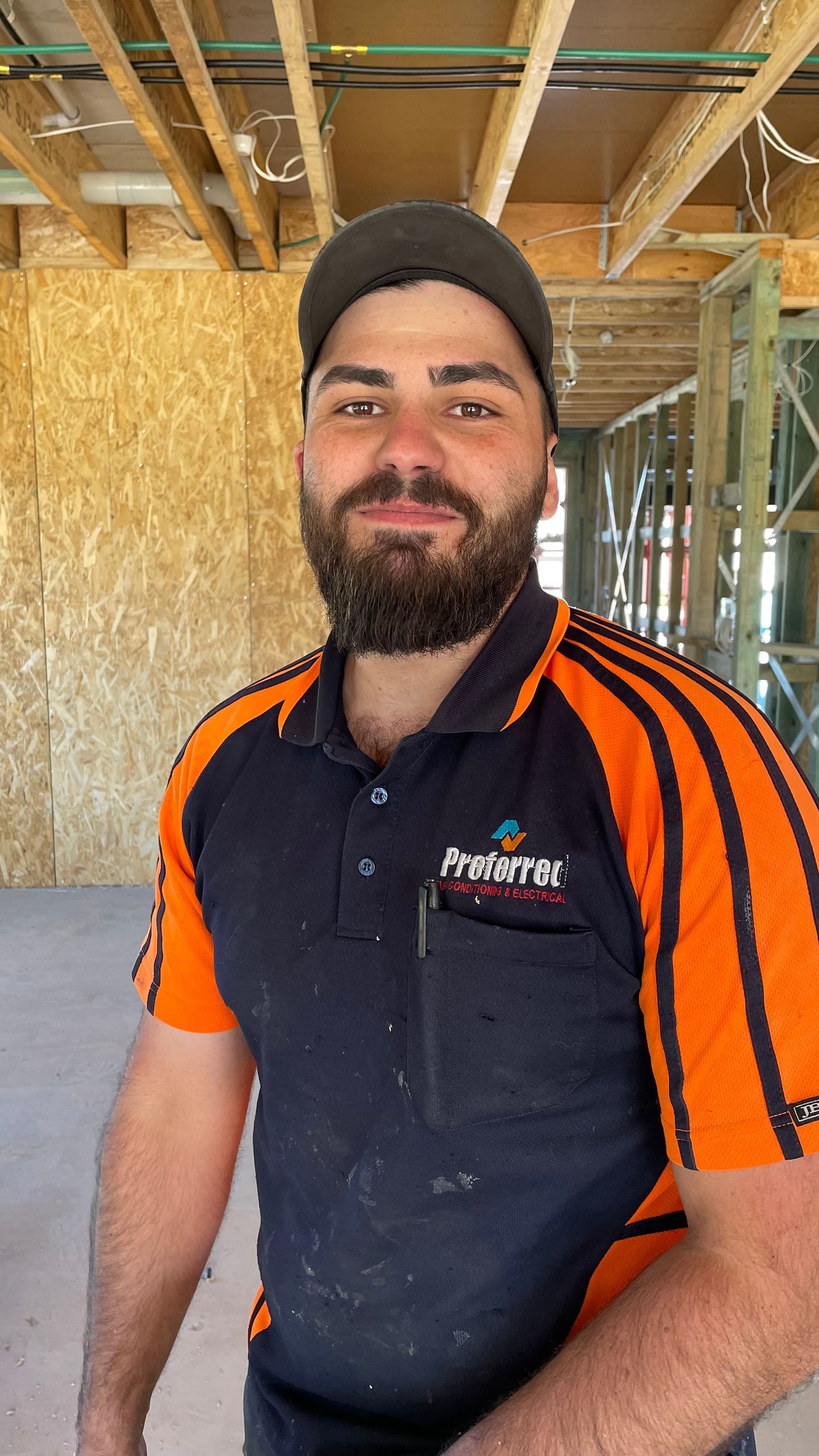 A man with a beard and a hat is standing in a building under construction.
