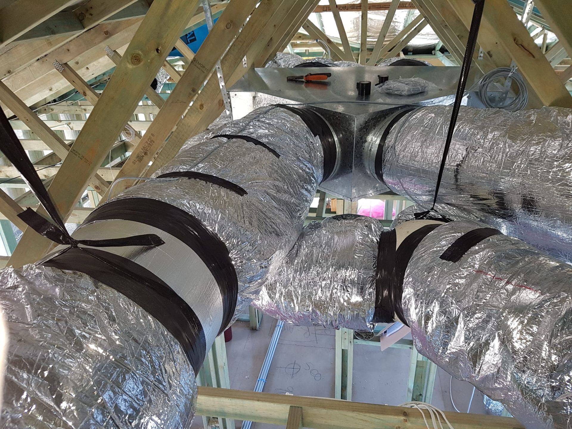 A bunch of ducts are hanging from the ceiling of a building.