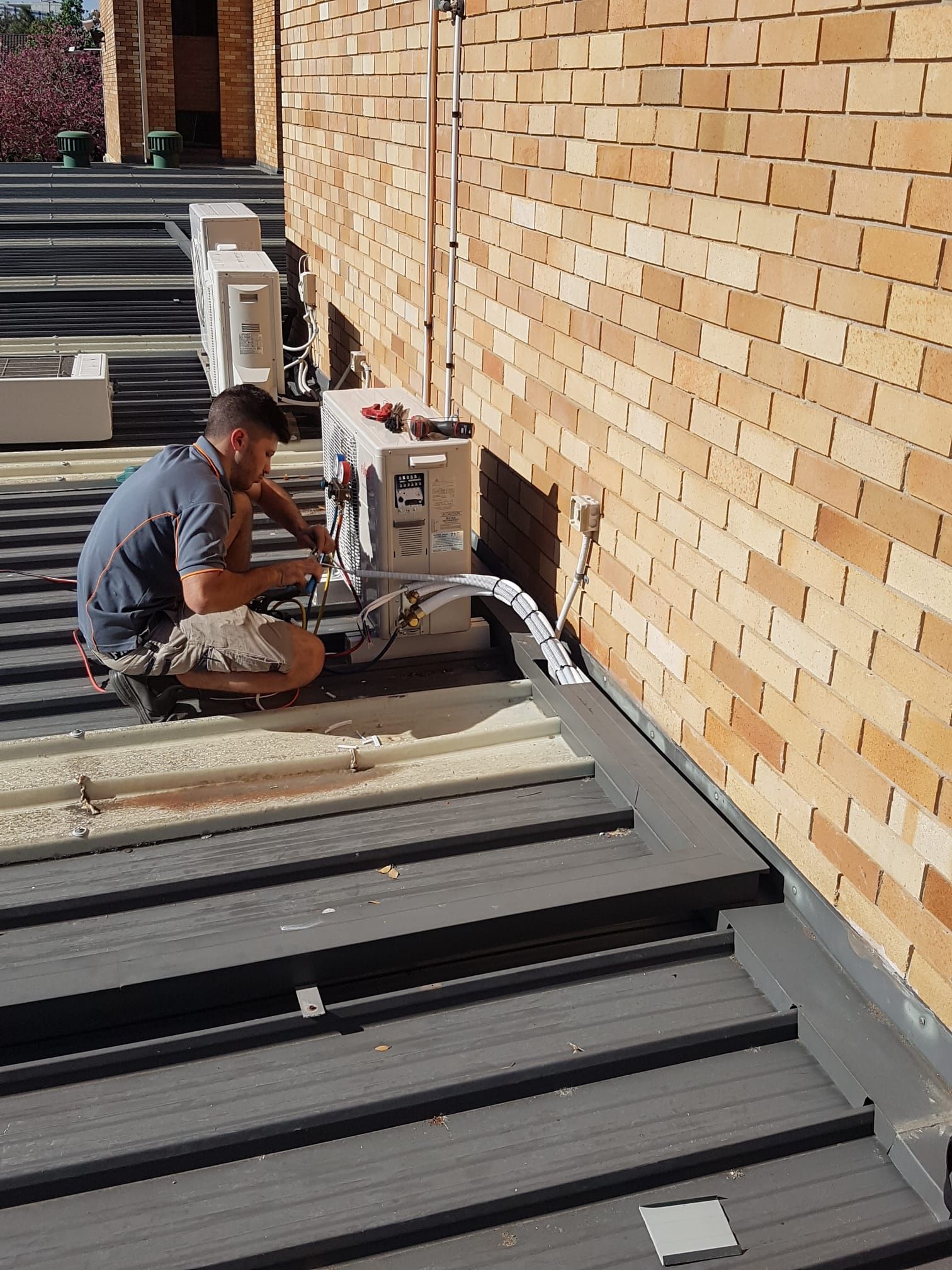 A man is installing an air conditioner on the wall.