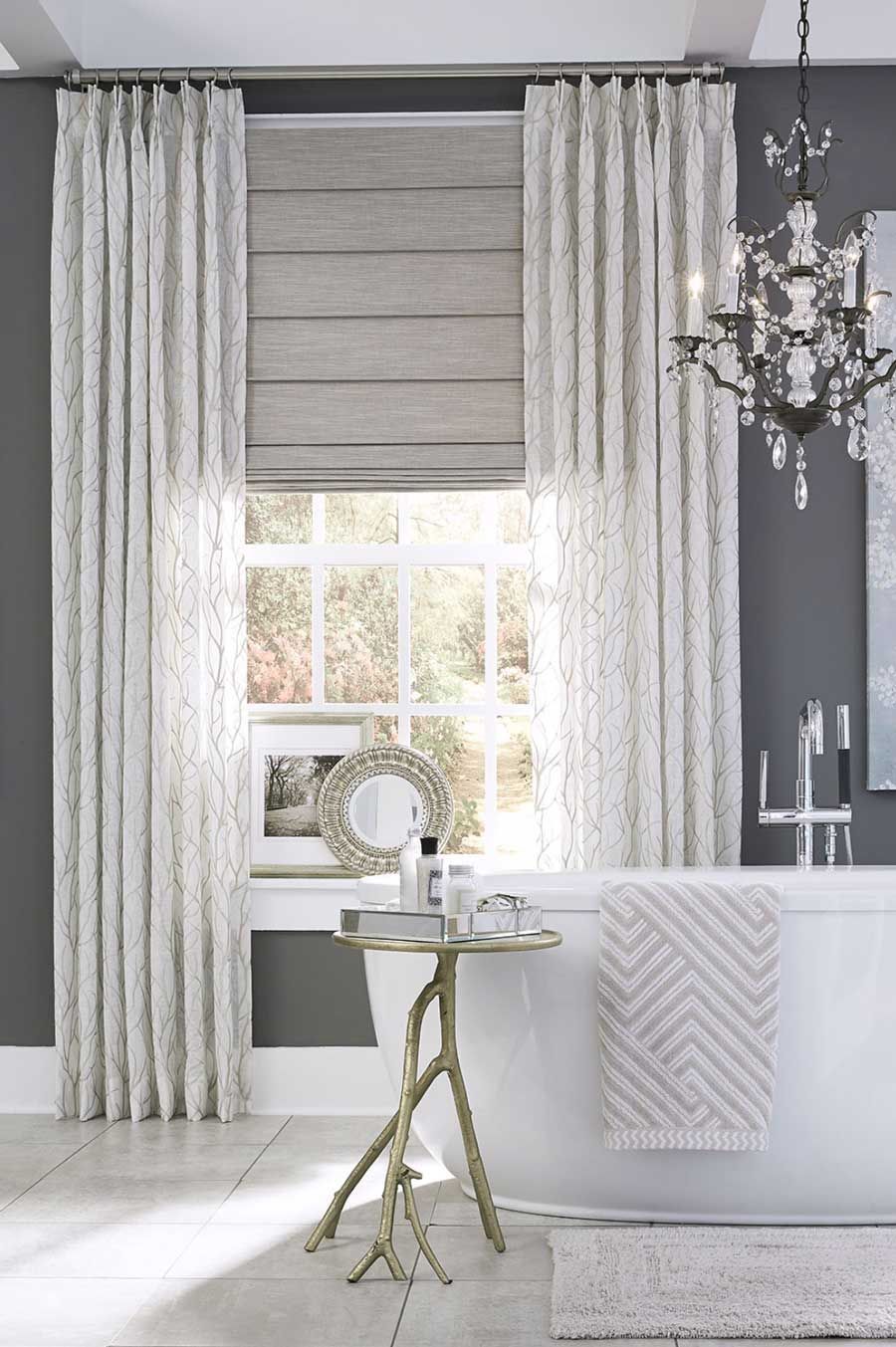 white and gray pinch pleat draperies with gray roman shade in primary bathroom