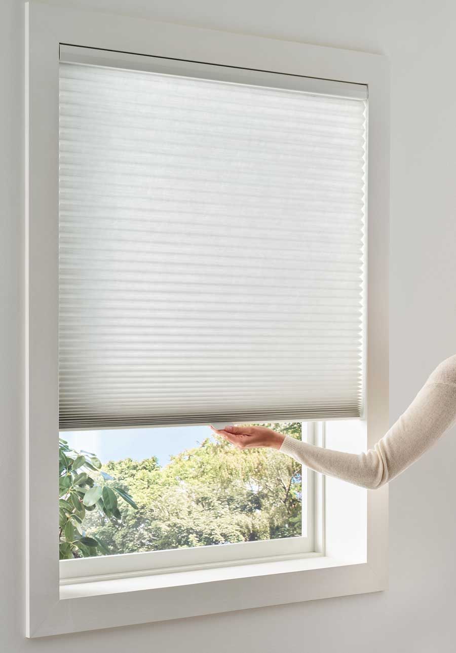 hand adjusts cordless shades with the literise system for child safe window coverings