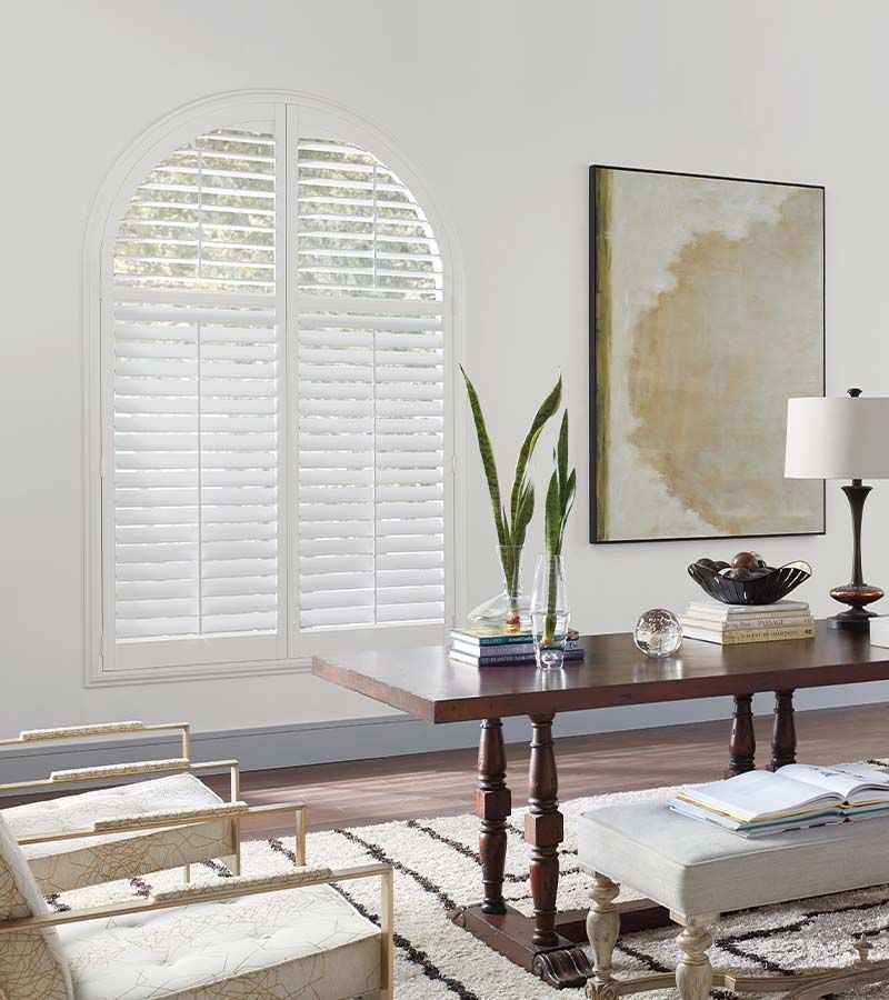 home office with white shutters behind desk