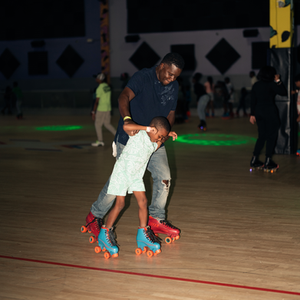 A man is helping a little girl roller skate