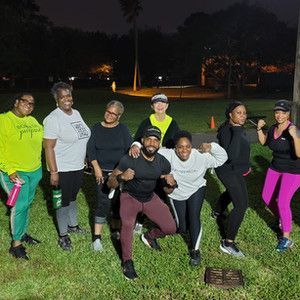 A group of people are posing for a picture in a park at night.