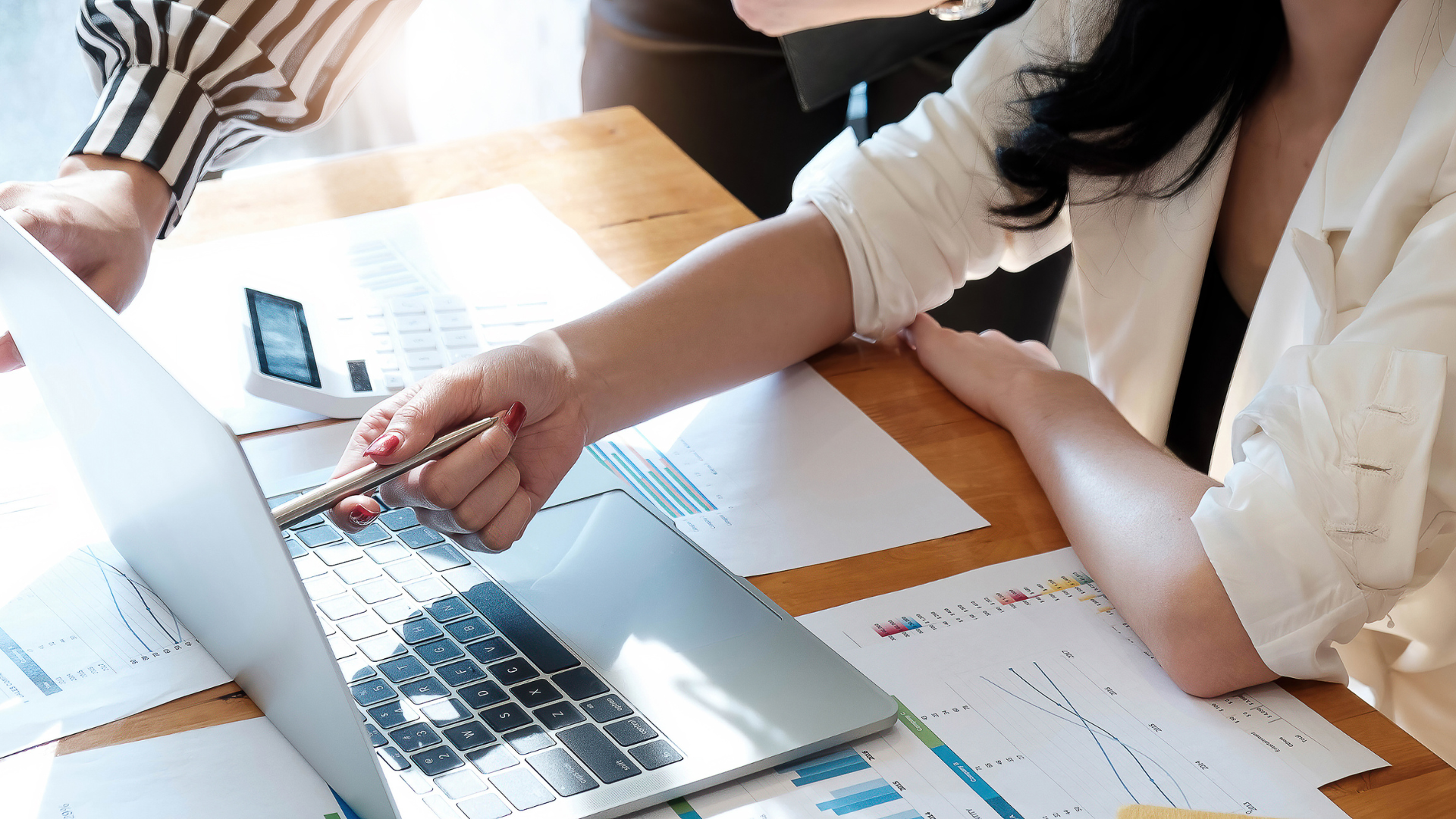 A woman is sitting at a table using a laptop computer.