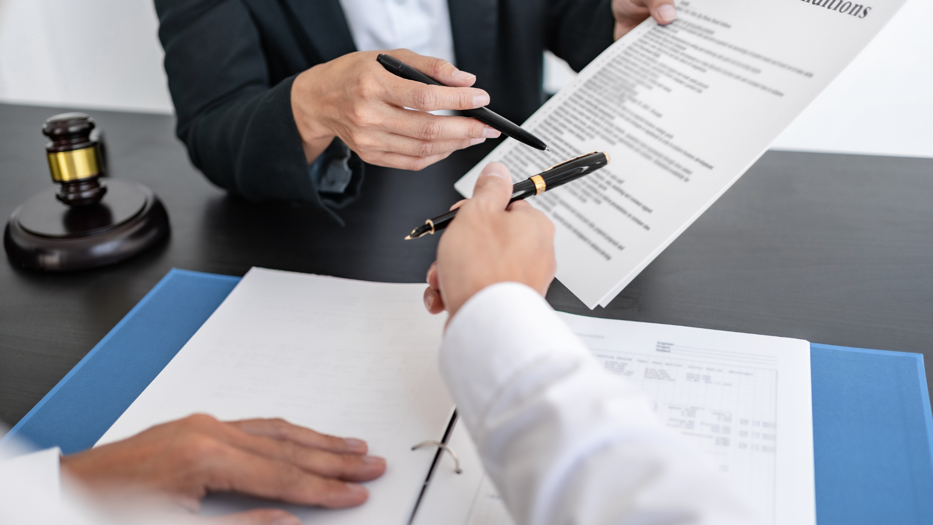 A man and a woman are sitting at a table looking at a piece of paper.