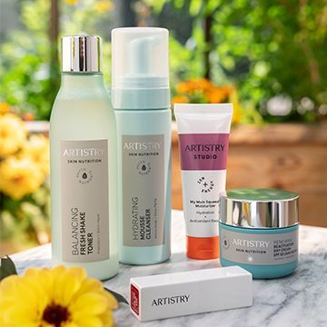 A table topped with bottles of artistry cosmetics.