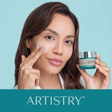 A woman is applying a cream to her face.