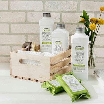 A wooden box filled with bottles of cleaning products and wipes.