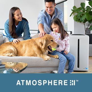 A family is sitting on a couch with a dog.