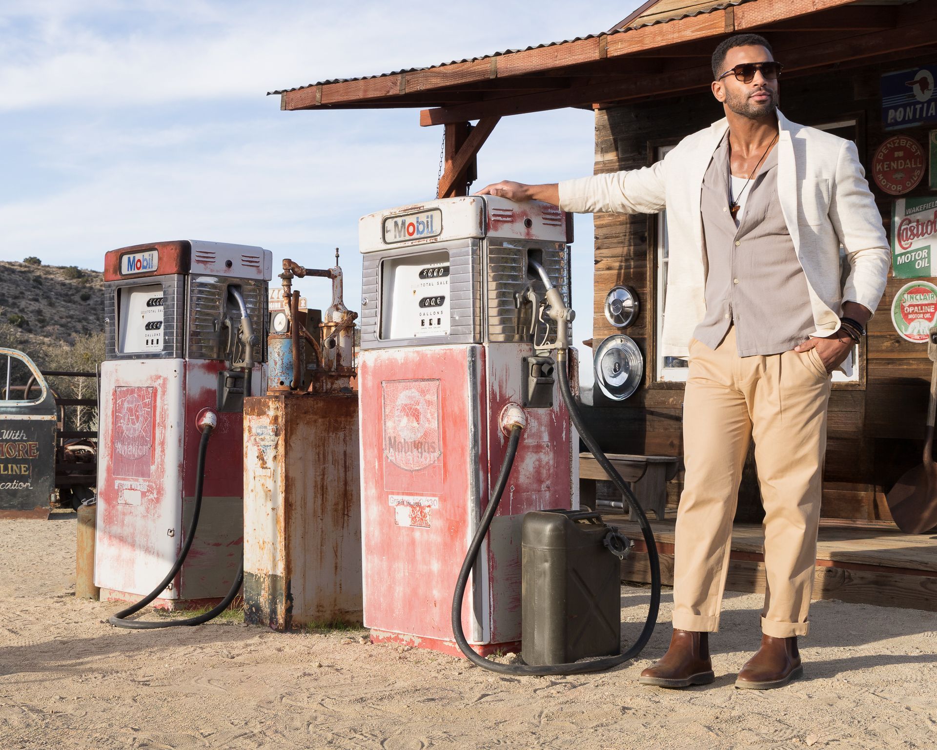 A man is standing in front of a gas pump that says ' coca cola ' on it