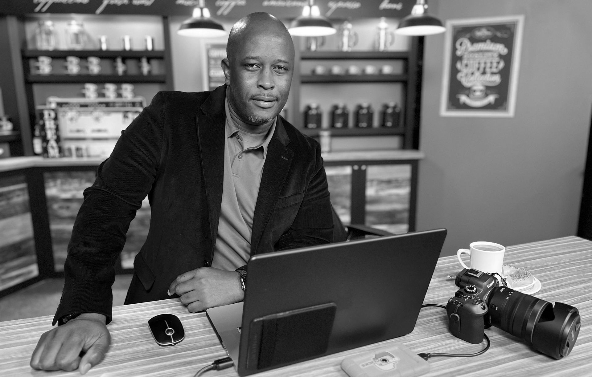 a black and white photo of Lenworth Johnson using a laptop