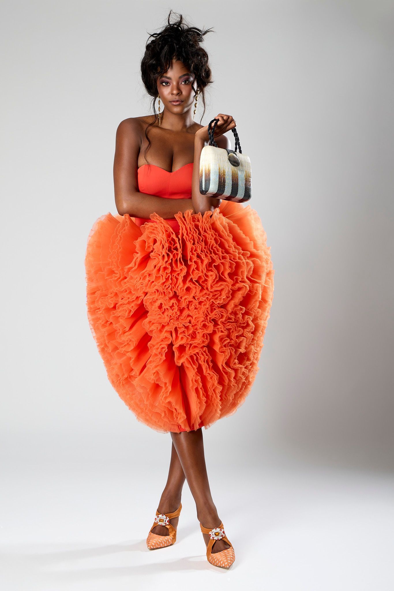 International top model wearing a orange puffer dress and earrings for NY Fashion week.