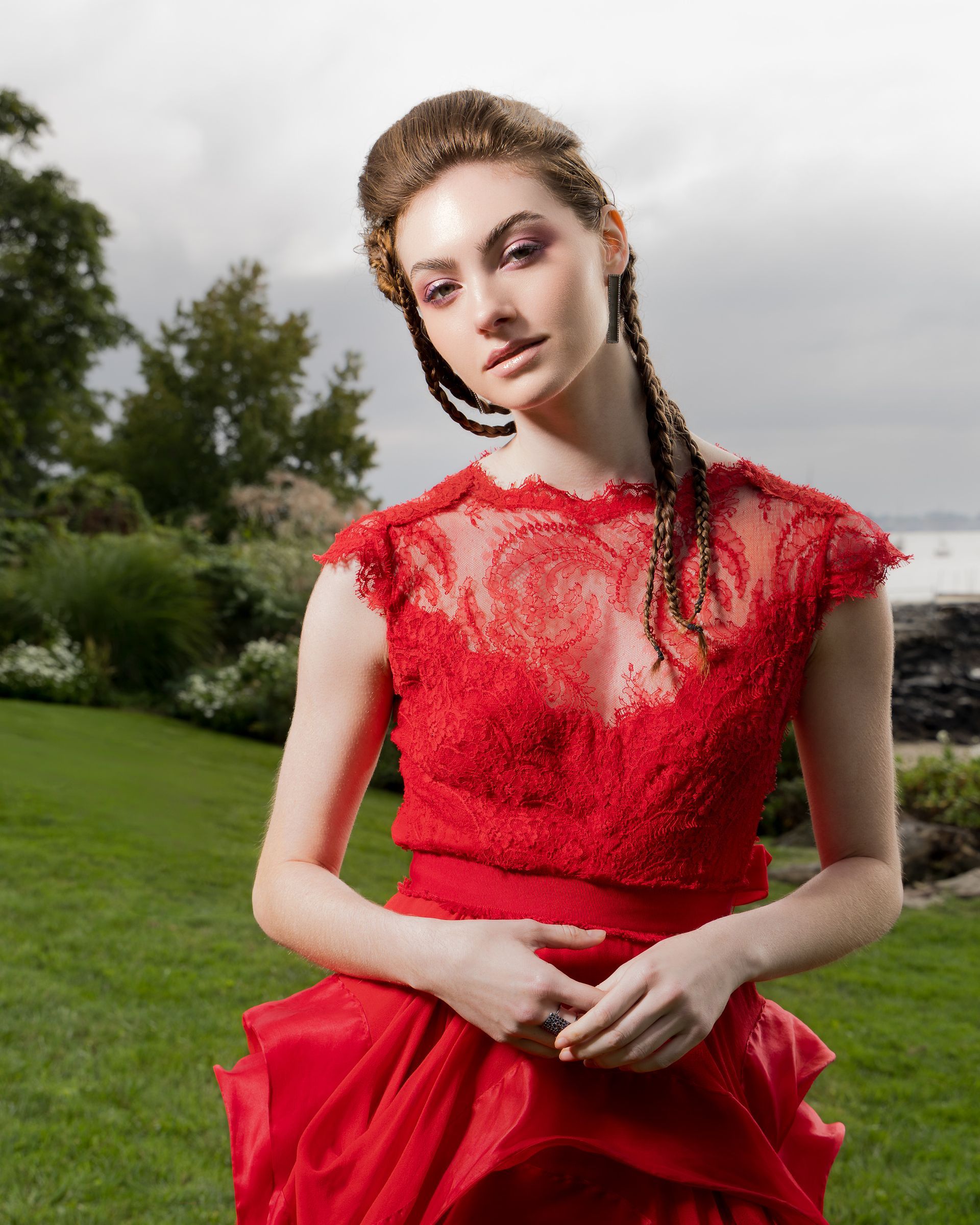 A woman in a red dress is standing in the grass