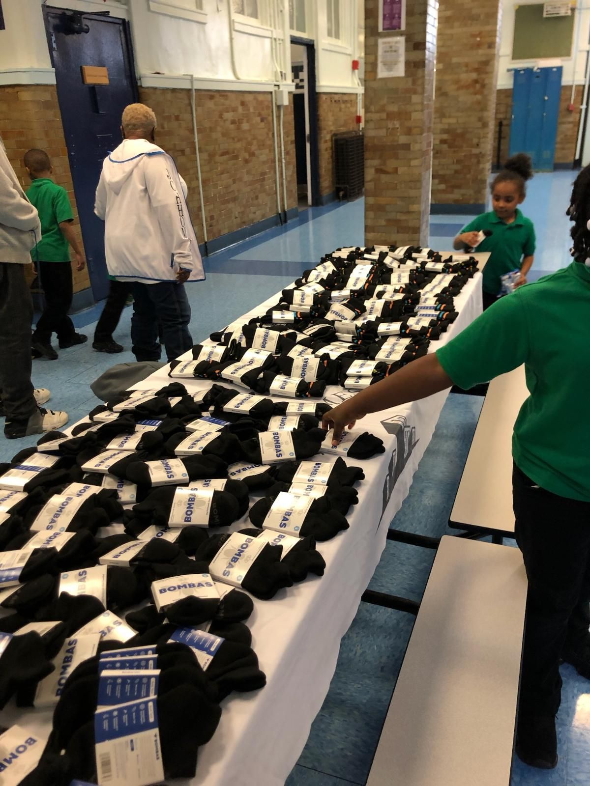 A group of people are standing around a table full of socks.