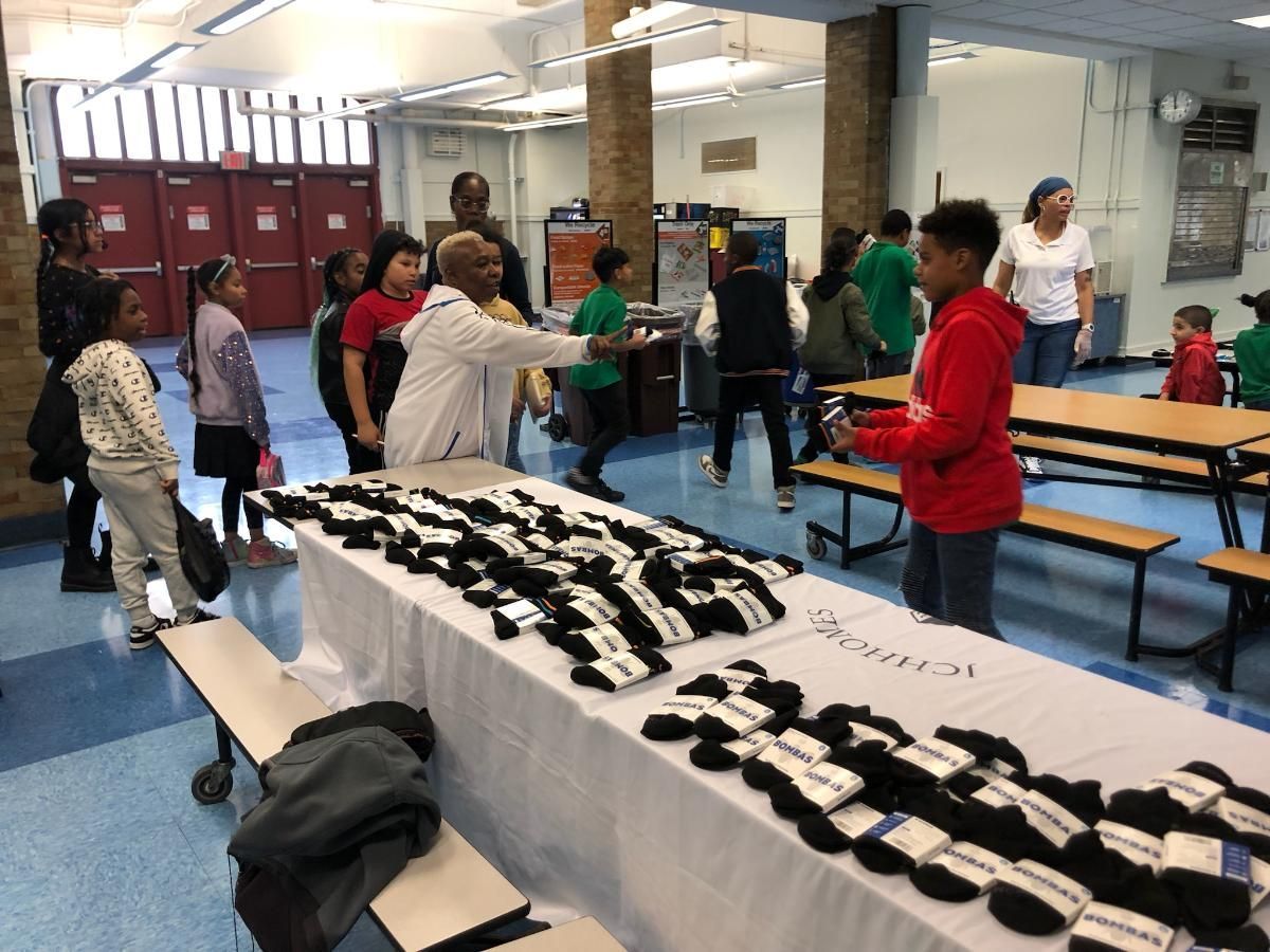 A group of people are standing around a table with socks on it.