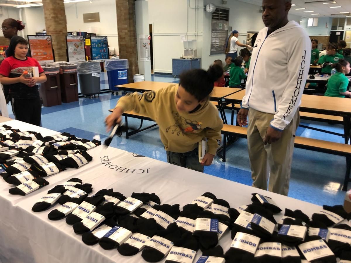 A girl is looking at a table full of socks.