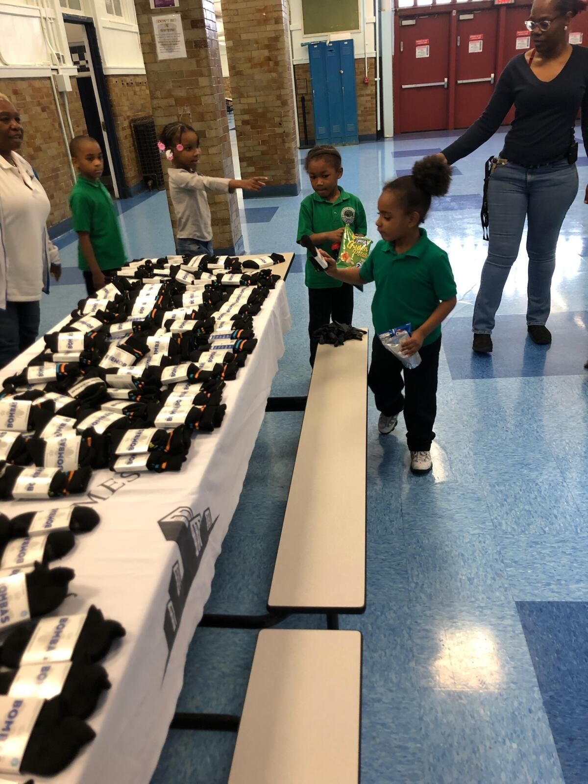 A group of children are standing around a table full of socks