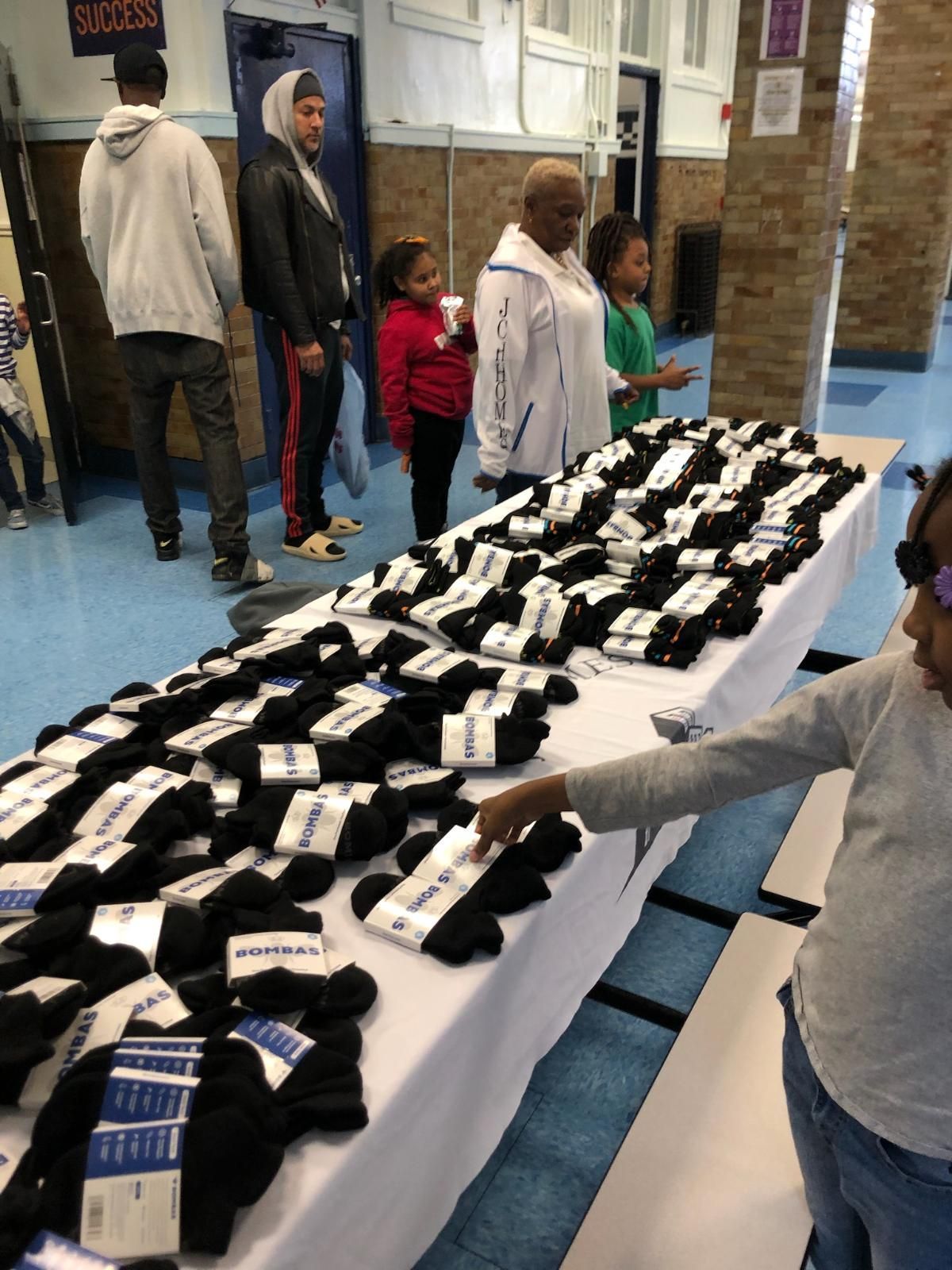 A group of people are standing around a table full of socks