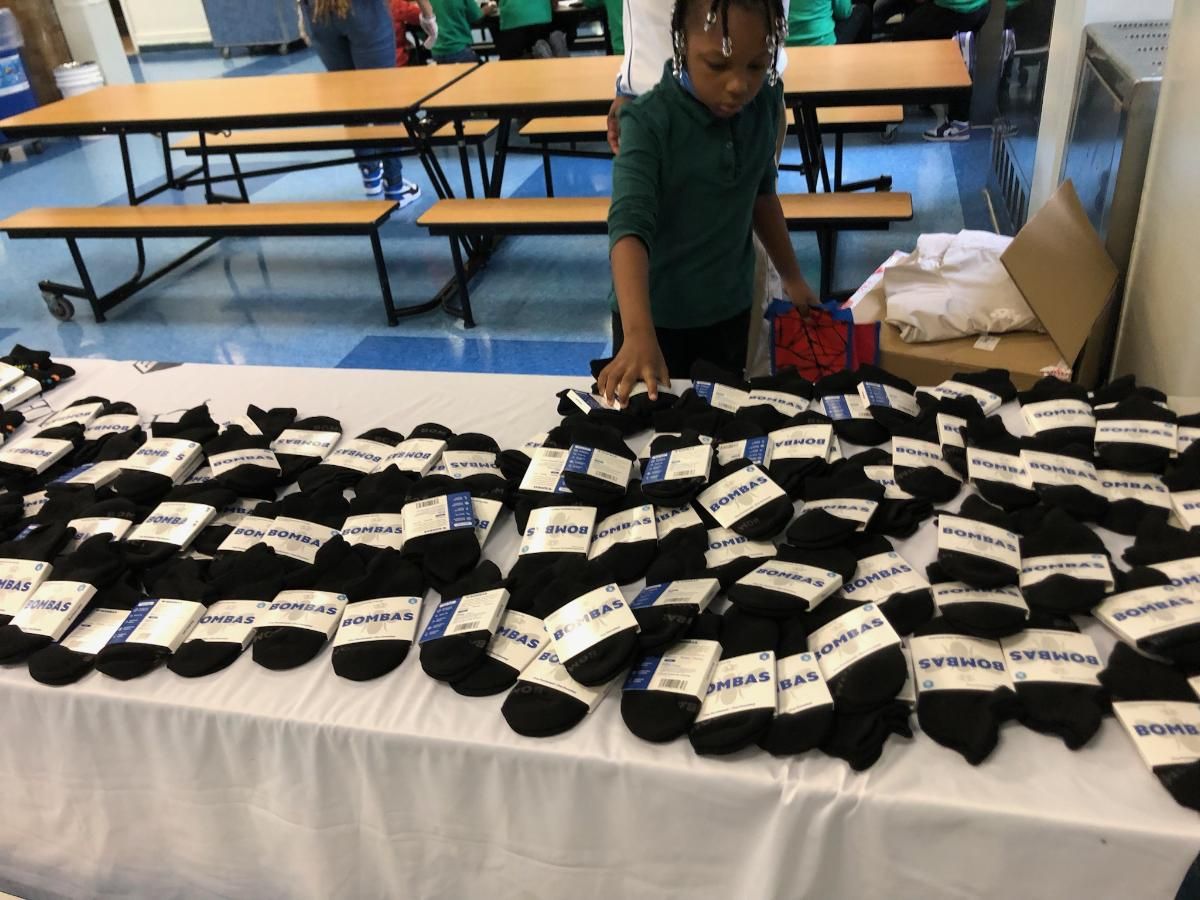A boy is standing in front of a table full of socks