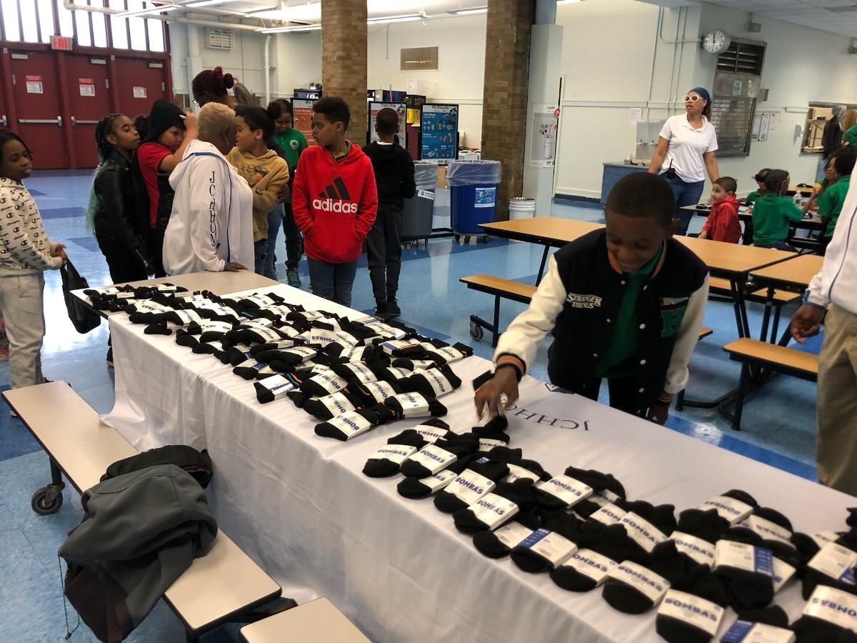 A group of people are standing around a table with socks on it.