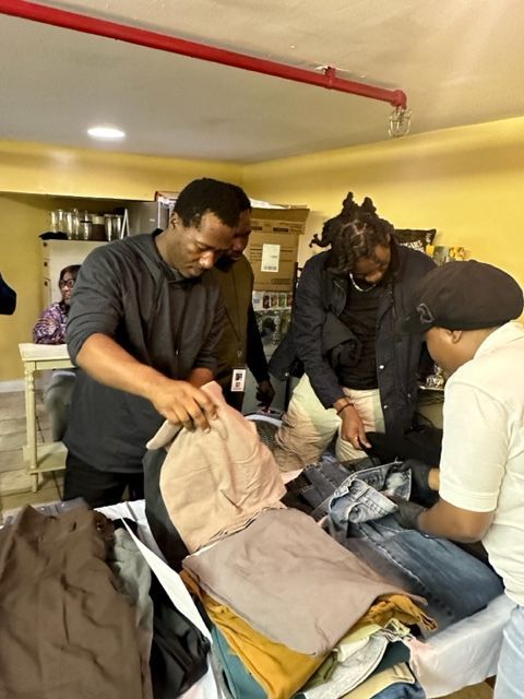 A group of people are standing around a pile of clothes