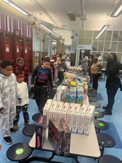 A group of children are standing around a table with toys on it.