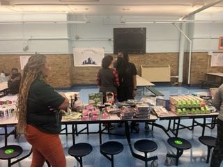 A group of people are standing around tables in a room.
