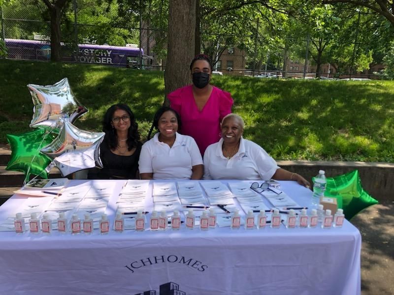 A group of women are sitting at a table in a park.