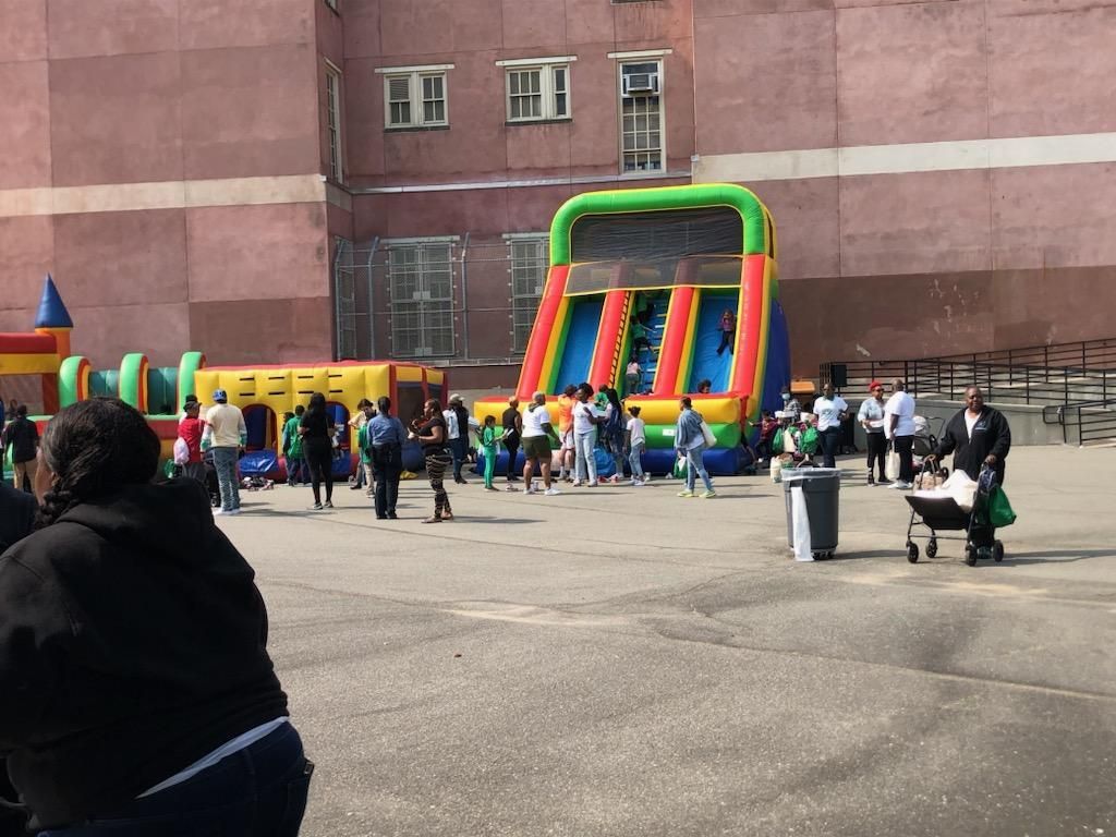 A group of people are standing around a bouncy house