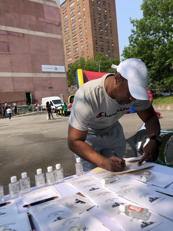 A man in a champion shirt is writing on a piece of paper