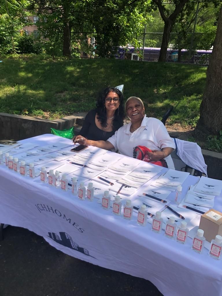 Two women are sitting at a table in a park.