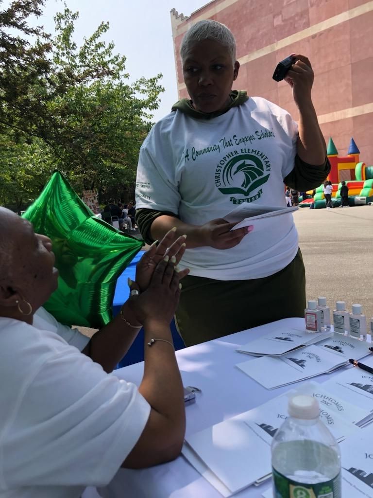 A woman in a white shirt is talking to another woman at a table.